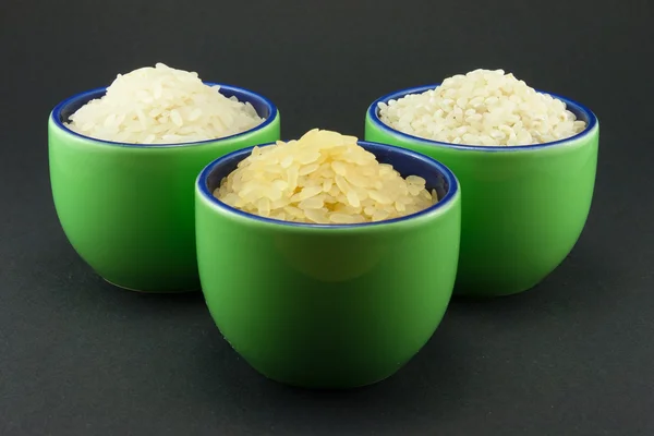 Tre sorters ris i tre små gröna koppar — Stockfoto