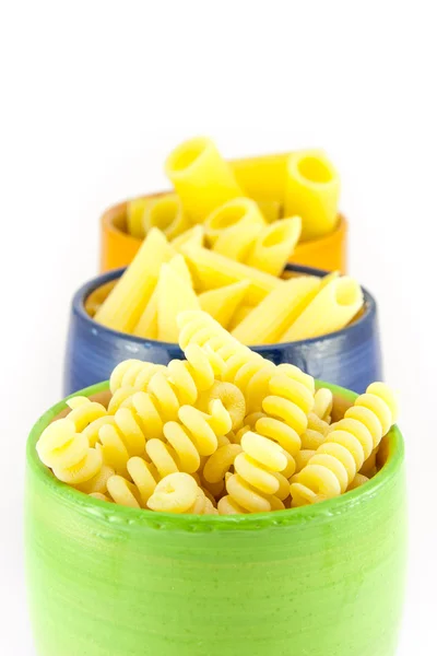 Fusilli, rigatoni en pennen pasta in een groene, blauwe en oranje pot — Stockfoto