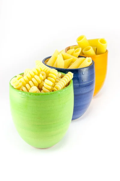 Těstoviny Fusilli, kolínka a pera v modré, zelené a oranžové sklenice — Stock fotografie