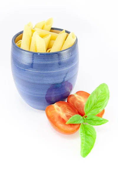 Kalem makarna domates ve fesleğen ile mavi bir kavanoz içinde — Stok fotoğraf
