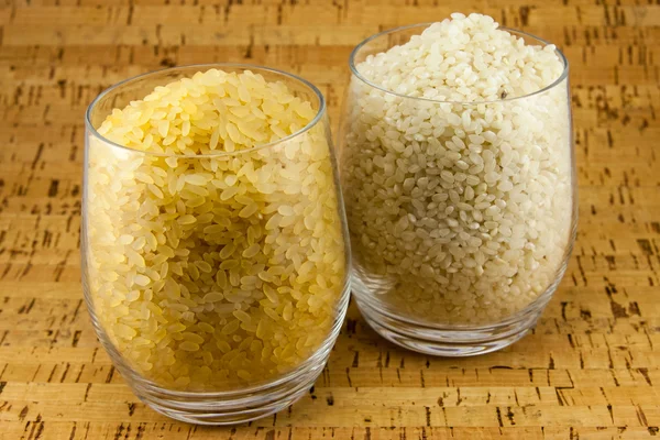 Two varieties of rice inside two transparent glasses — Stock Photo, Image