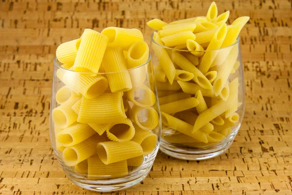 Two varieties of pasta inside two transparent glasses — Stock Photo, Image