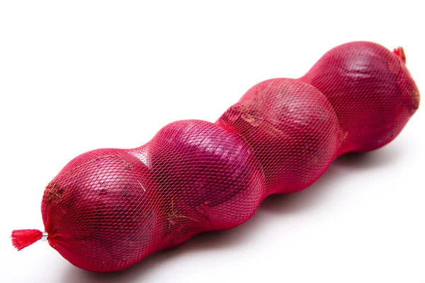 Cebollas rojas crudas en la red — Foto de Stock