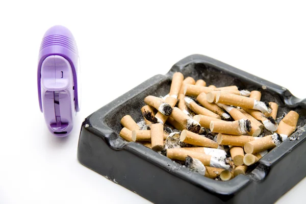 Aschenbecher mit Zigaretten und Inhalator — Stockfoto