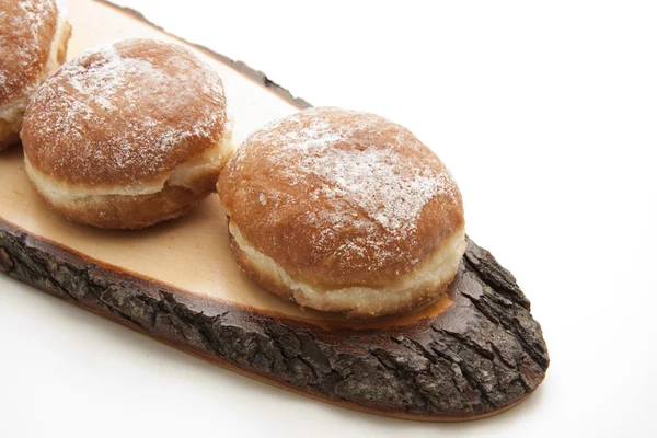 Donuts on wooden plate with bark — Stock Photo, Image
