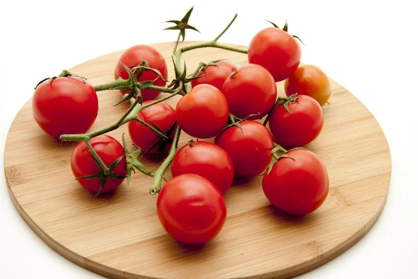Tomates de arbusto em chapa de madeira — Fotografia de Stock