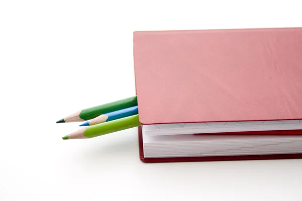 Colored pencils on book — Stock Photo, Image