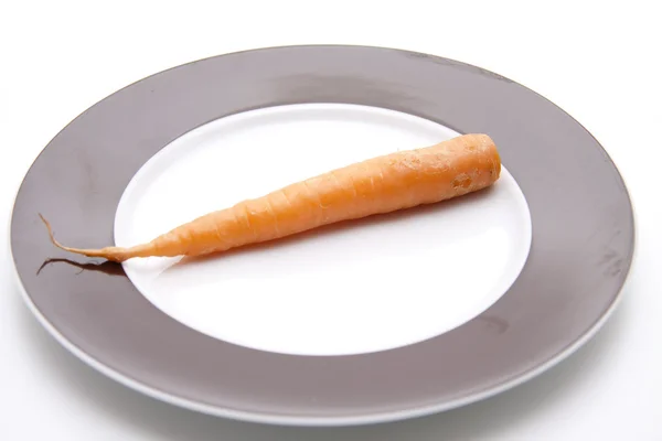Carrot on ceramics plate — Stock Photo, Image