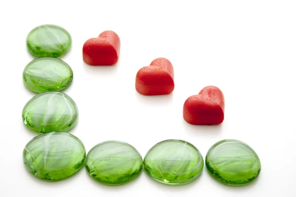 Зеленые стеклянные камни и сердце — стоковое фото