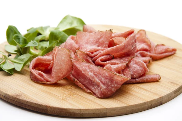 Salami segmenten met salade blad — Stockfoto