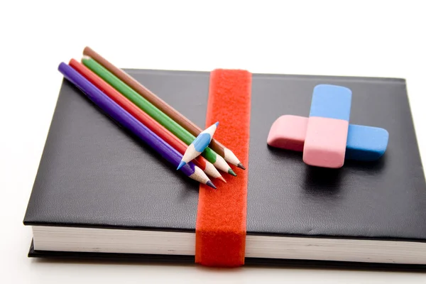 Coloured pencils with notebook — Stock Photo, Image