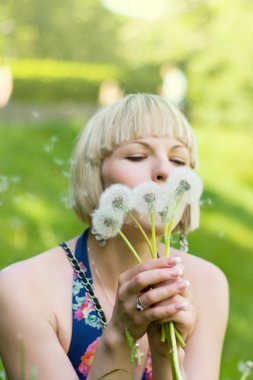 Şişirme Dandelion üzerinde bir genç kız