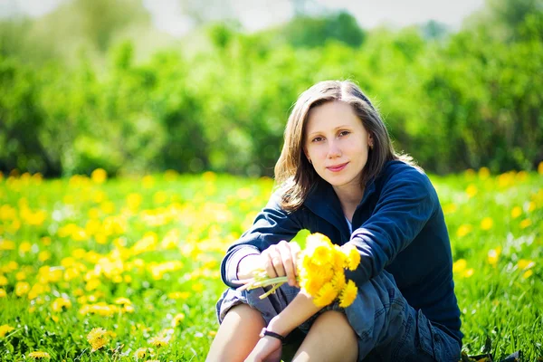 Girl with bunch of yellow dandelions — Stock Photo, Image