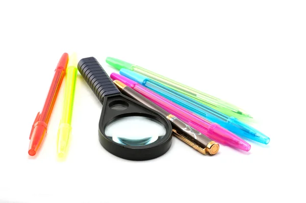 Bolígrafos, bolígrafos y lupa — Foto de Stock