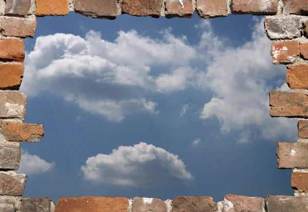 Vieja pared de ladrillo como un marco grueso con el cielo soleado —  Fotos de Stock