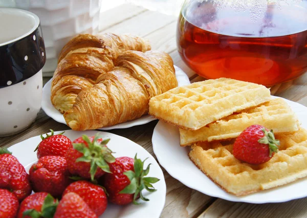 Tasty breakfast - tea, croissants, wafers with cream — Stock Photo, Image