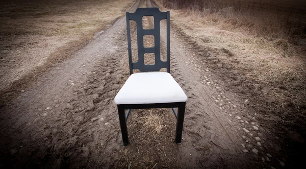 Cadeira vazia em uma estrada de terra — Fotografia de Stock