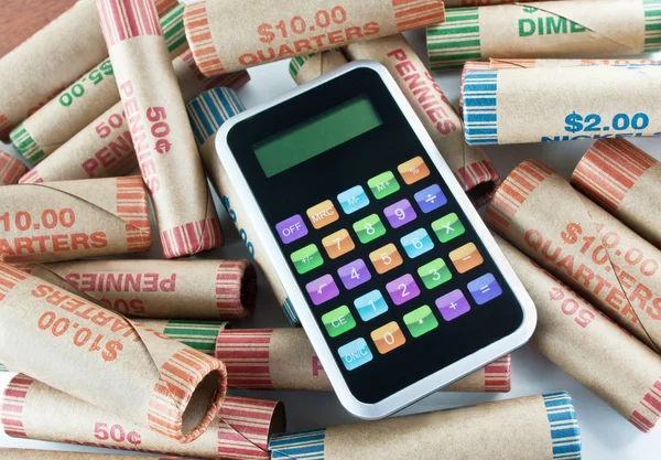 Kalkulator siedzi na monety opakowań — Zdjęcie stockowe