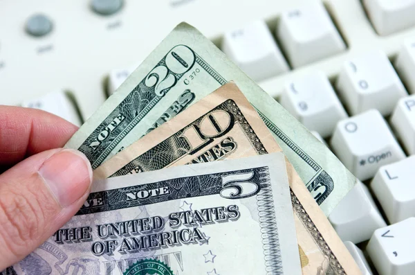 Dinheiro sobre teclado branco — Fotografia de Stock