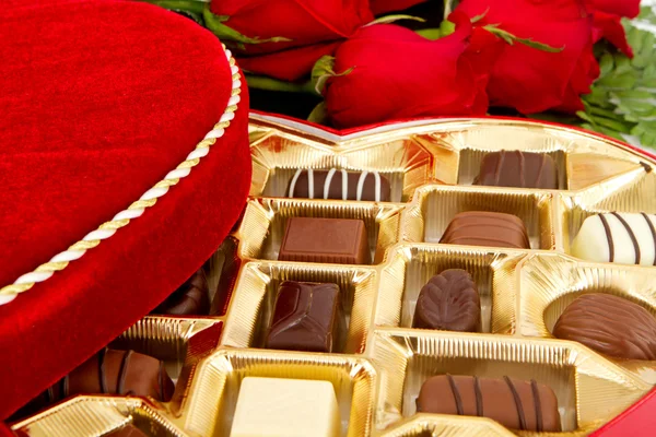 Doos van chocolade snoep met rode rozen — Stockfoto