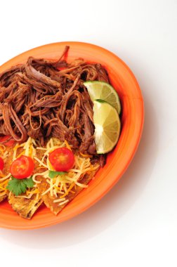 Shredded beef and tortillas with cheese on orange plate