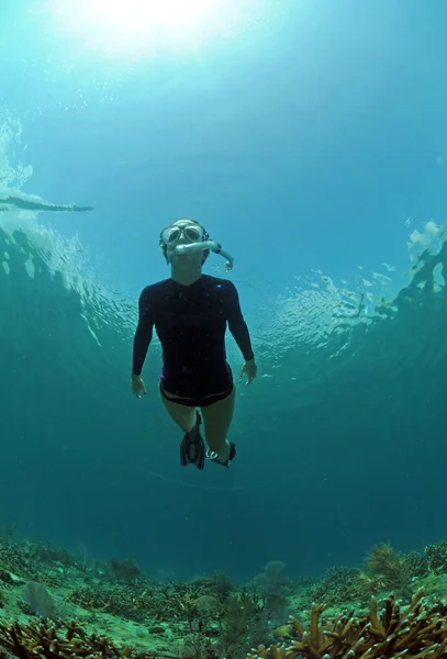 Женщина ныряет с маской под водой — стоковое фото