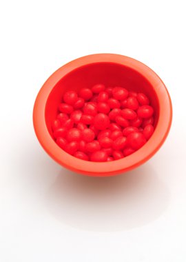 Red hots in bowl isolated on white clipart
