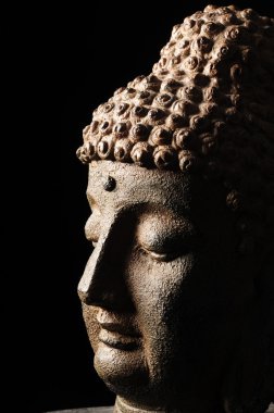 Buddha head isolated on black background clipart