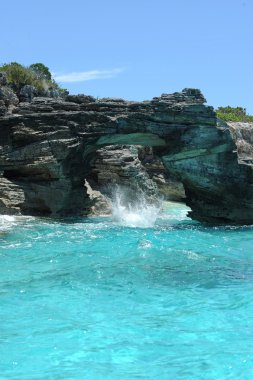 Blue water and rocks in scenic tropical setting clipart