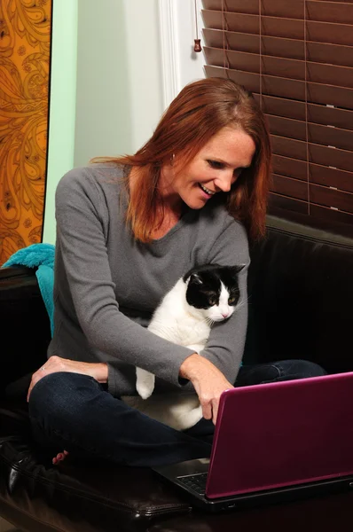 Cat and pretty woman looking at computer
