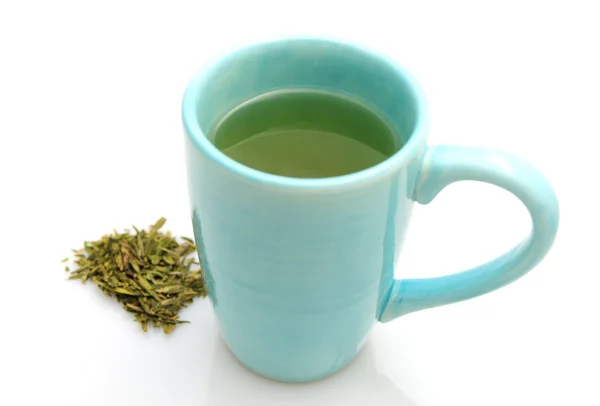 Beker van hete thee met groene bladeren — Stockfoto