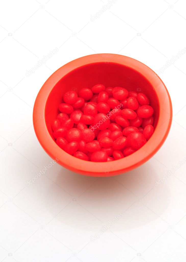 Red hots in bowl isolated on white