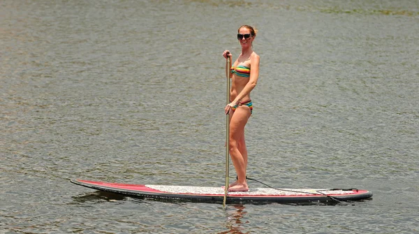 Kadın egzersiz paddleboarding tarafından elde — Stok fotoğraf