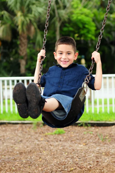 Heureux jeune enfant balançant — Photo