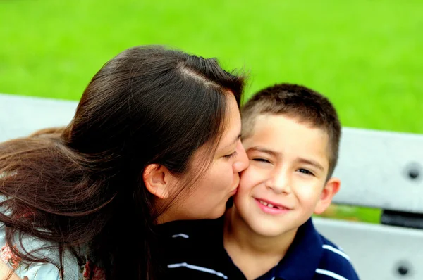 Mãe beijando seu filho na bochecha — Fotografia de Stock