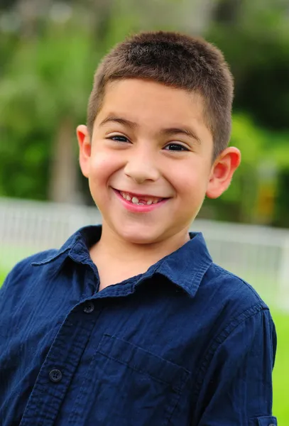 Gelukkig latino kind lacht met ontbrekende tand — Stockfoto