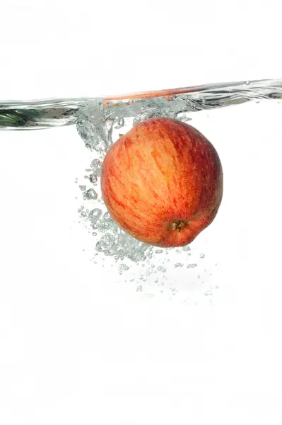 Salpicos de maçã vermelha em água clara — Fotografia de Stock