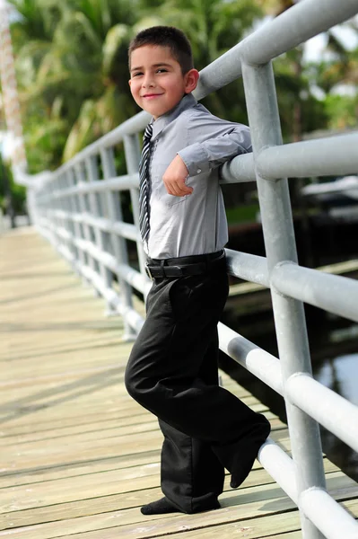 Симпатичный мальчик прислонился к столбу на мосту — стоковое фото