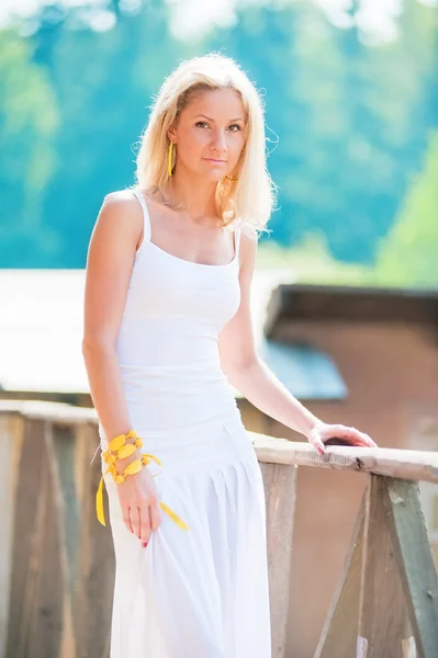 Junge schlanke Frau in Weiß am Geländer — Stockfoto