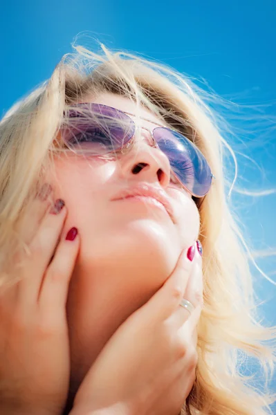 Portret van een jonge vrouw dragen van een zonnebril, op zoek naar de hemel. — Stockfoto