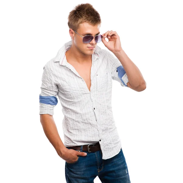 Красивый молодой человек в джинсах, легкой рубашке и солнечных очках — стоковое фото