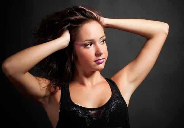 Elegante junge Frau auf dunklem Hintergrund — Stockfoto