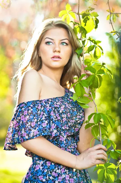 Aantrekkelijk meisje in blauwe jurk buiten in het veld. — Stockfoto