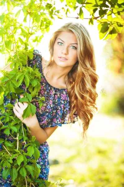 Aantrekkelijk meisje in blauwe jurk buiten in het veld. — Stockfoto