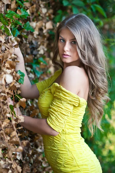 Young attractive girl in yellow dress outdoor in the field — Stock Photo, Image