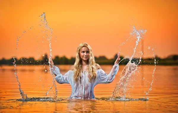 Sexy blonde woman in water at sunset .Beautiful swimsuit model in the water — Stock Photo, Image