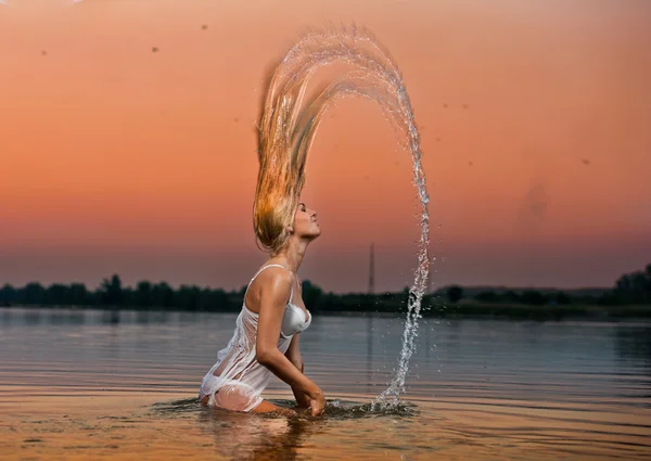 性感的金发女人在日落.beautiful 泳装模型在水中水中 — 图库照片