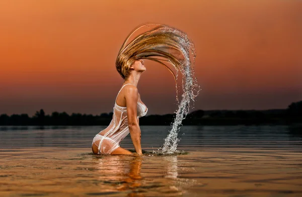 Sexy blond žena ve vodě při západu slunce krásné plavky model ve vodě — Stock fotografie