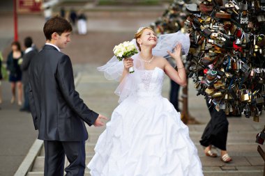 Happy bride and groom at wedding walk on Luzhkov bridge clipart