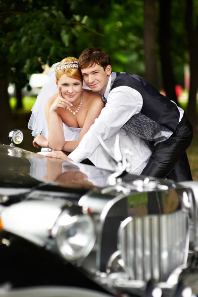 Noivo adn noiva sobre a limusine retro — Fotografia de Stock